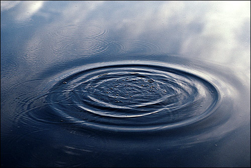 Поверхность воды с расходящимися по ней кругами. Фото, фотография